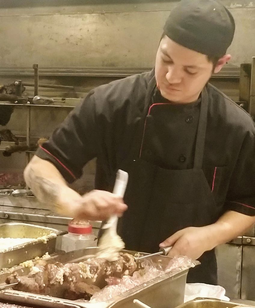 The chef coating a skewer in garlic