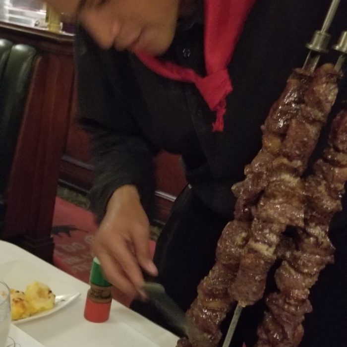 Waiter serving grilled meat