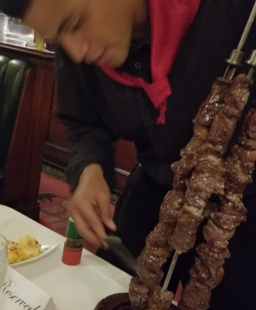 Waiter serving grilled meat