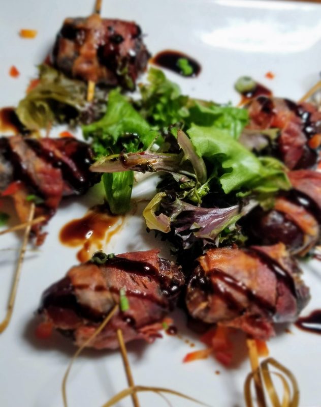 Bacon-wrapped Stuffed Dates stuffed with feta cheese and drizzled with fig balsamic reduction